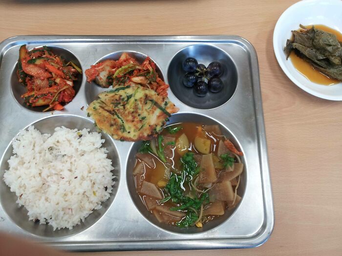 Plate with rice, soup, kimchi and fruits