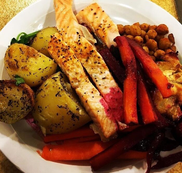 Plate with fried salmon, fried potatoes in herbs, honey roasted vegetables with chèvre