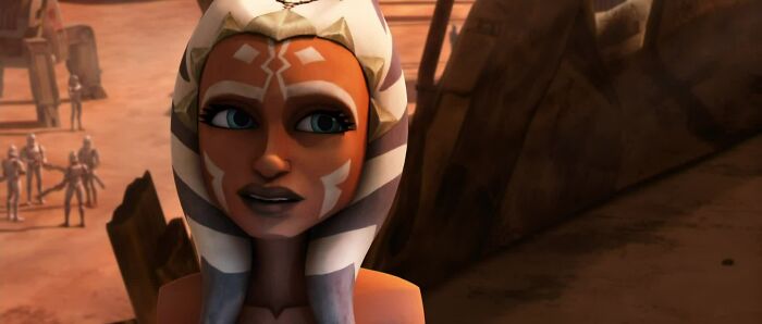 Ahsoka Tano standing in a desert environment, showcasing her strength and fame as a female cartoon character.