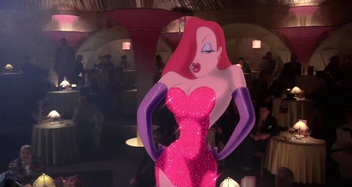 Female cartoon character in a red dress and purple gloves performing on stage, showcasing fame and strength.