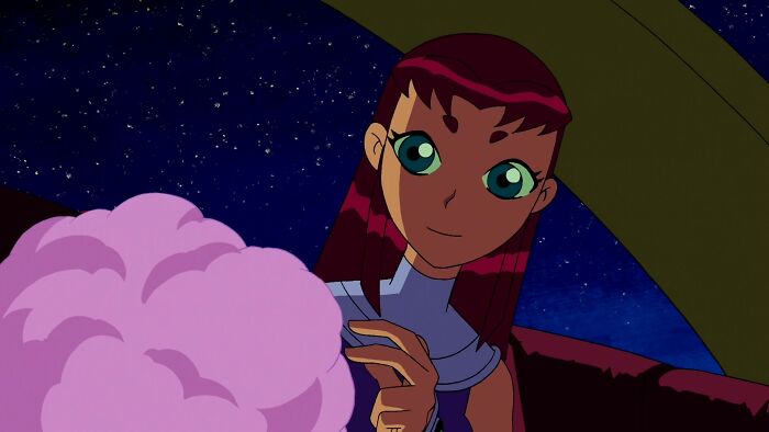 Female cartoon character with pink hair, large green eyes, admired for fame and strength, holding pink cotton candy under the night sky.