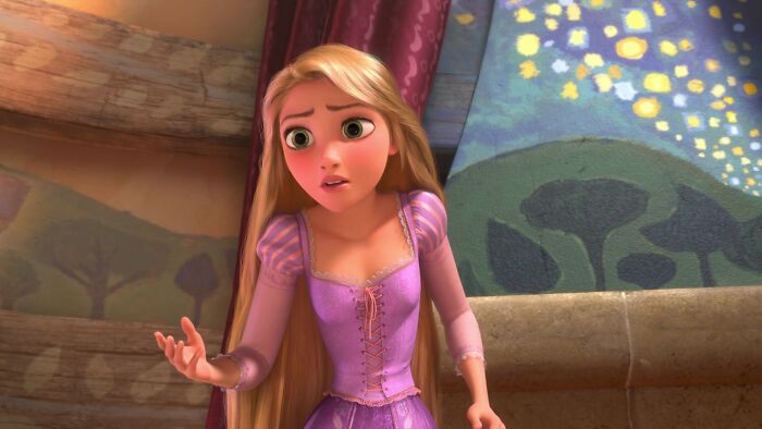 Female cartoon character with long blonde hair in a purple dress, showing expression of concern inside a colorful room.