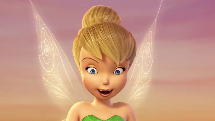 Blonde female cartoon character with wings, smiling against a sunset background, representing fame and strength.
