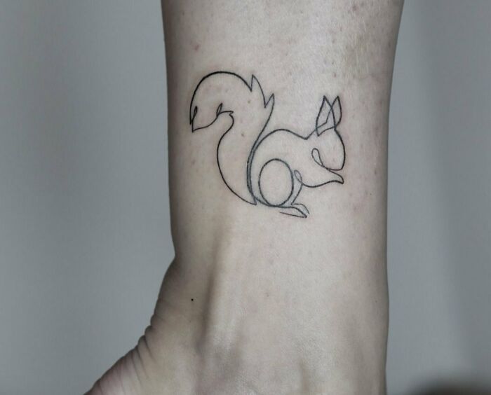 Fine-line tattoo of a squirrel on a person's ankle.