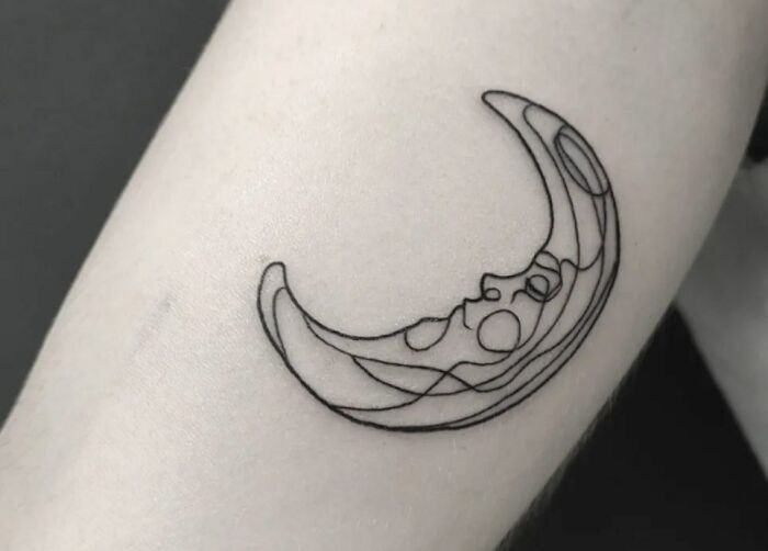 Fine-line single-line moon tattoo on forearm, showcasing minimalist design.
