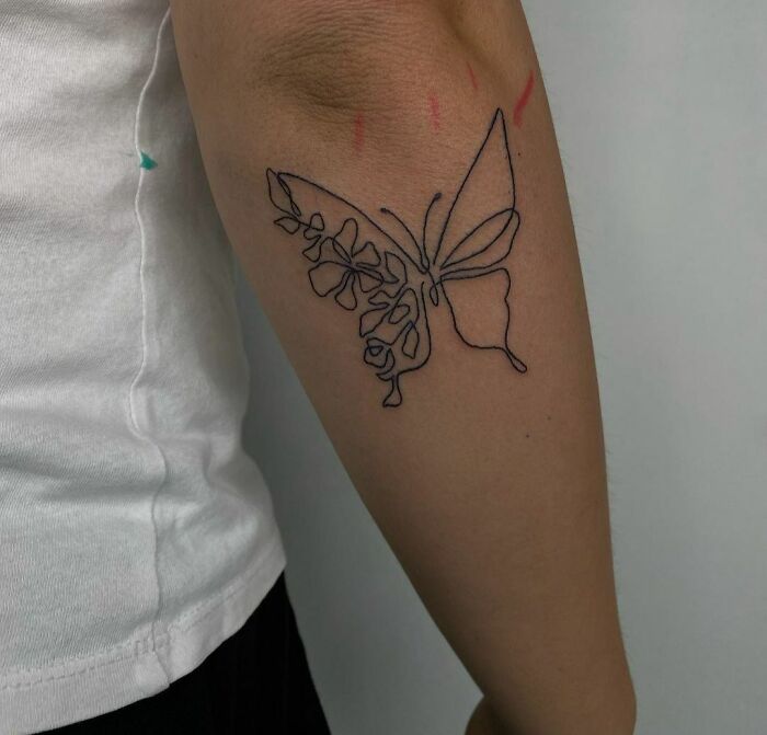 Fine-line single-line butterfly tattoo on forearm, showcasing artistic minimalism.