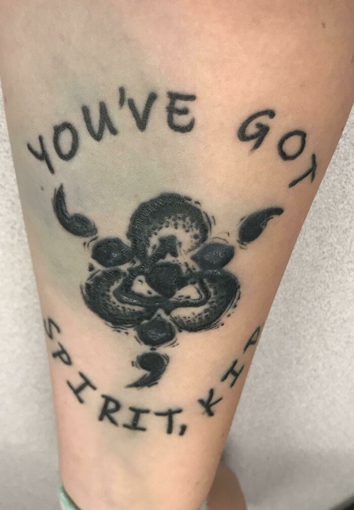 Funny tattoo with the text "YOU'VE GOT SPIRIT, KID" and a unique black ink design in the center.