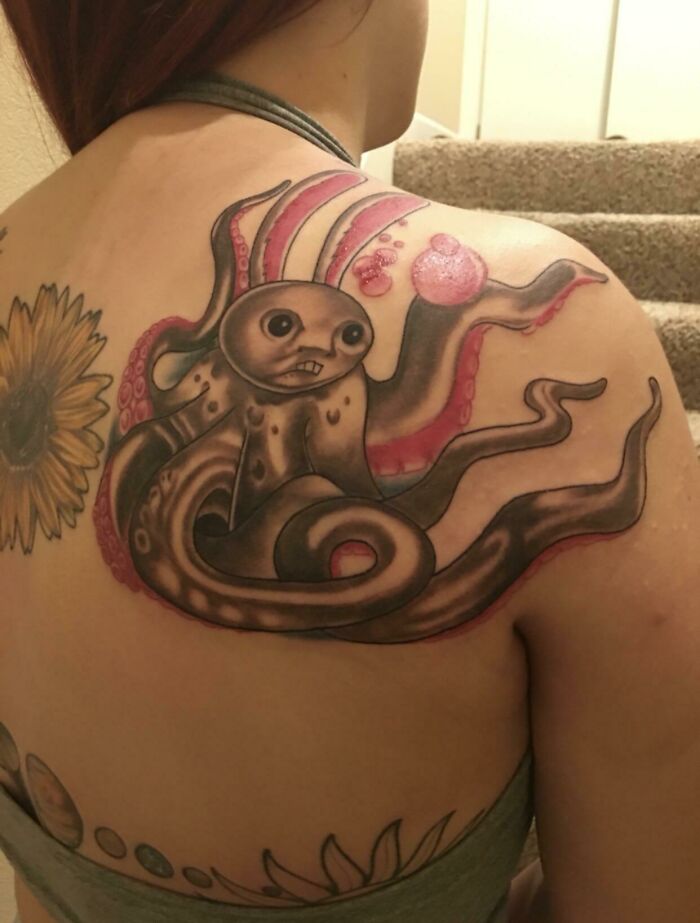 Funny tattoo of a quirky octopus on a person's shoulder.