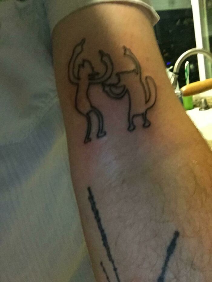 Funny tattoo of two dancing cats on a person's arm.