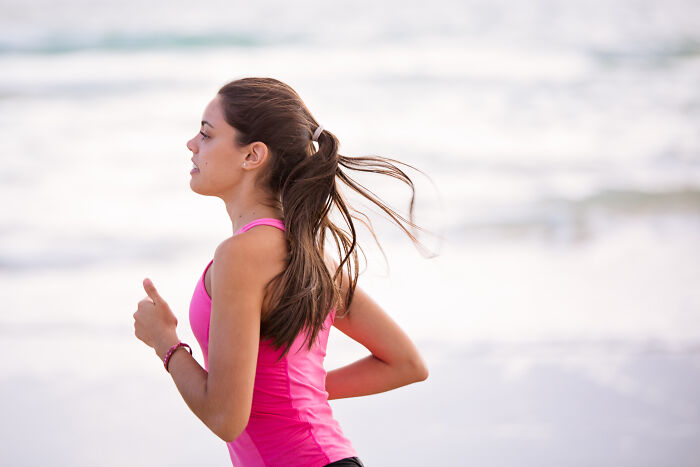 Woman running in the beach near water 
