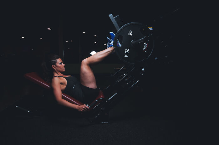 Woman using equipment for a leg training 