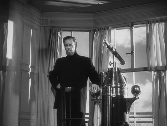 Rex Harrison in a jacket and turtleneck in a classic movie scene, representing famous people who got married multiple times.
