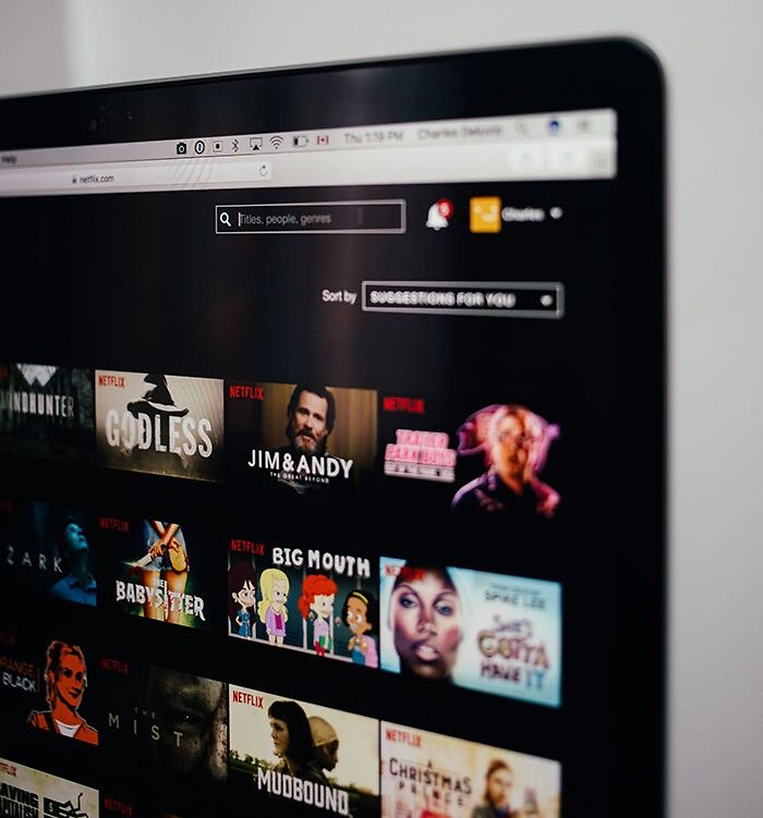 Laptop screen displaying Netflix interface with various titles, related to texting games and phone conversation ideas.