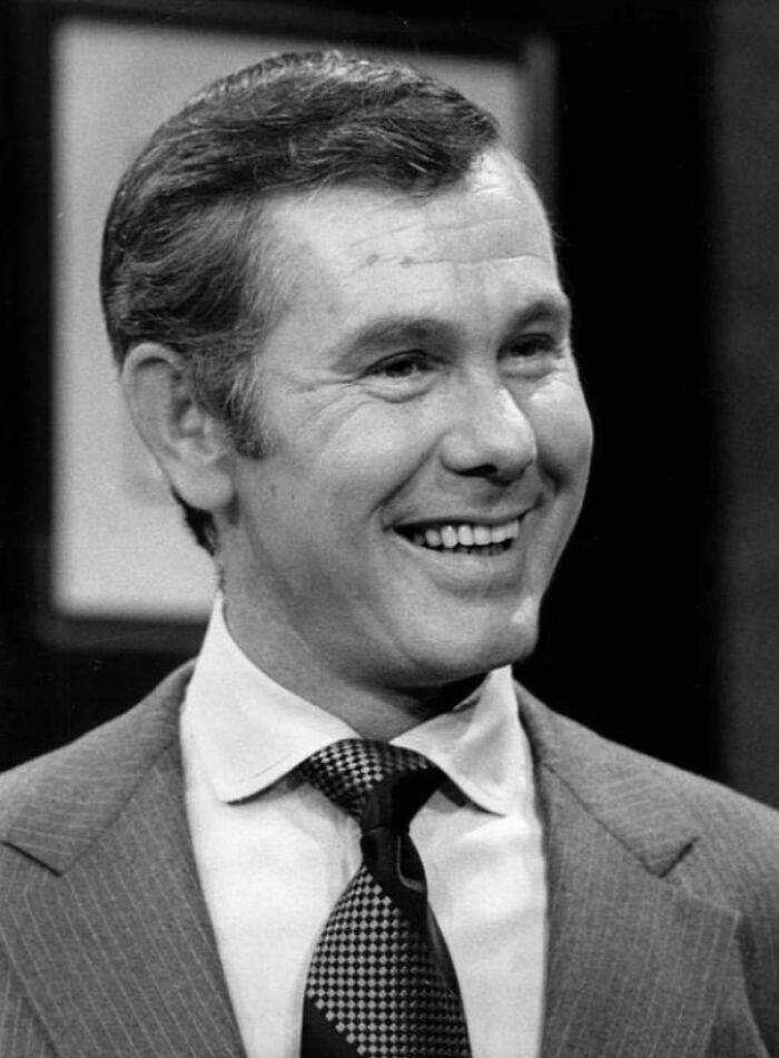 Johnny Carson wearing a suit and smiling, one of the famous people who got married multiple times in history.