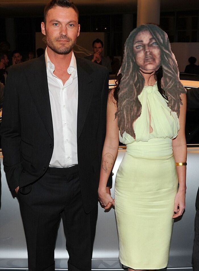 A couple posing at an event; the woman has an unusual tattoo on her arm.