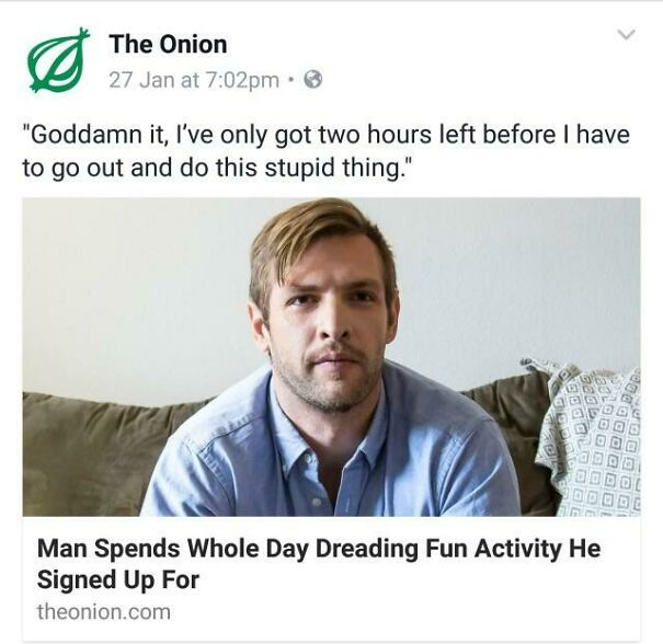 Man with social anxiety sitting on a couch, dreading an upcoming event he reluctantly agreed to attend.