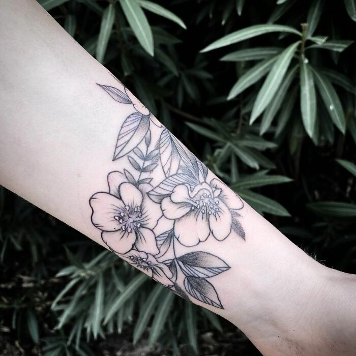 Floral mom tattoo on forearm symbolizing the mother-child bond, with detailed blossoms and leaves.