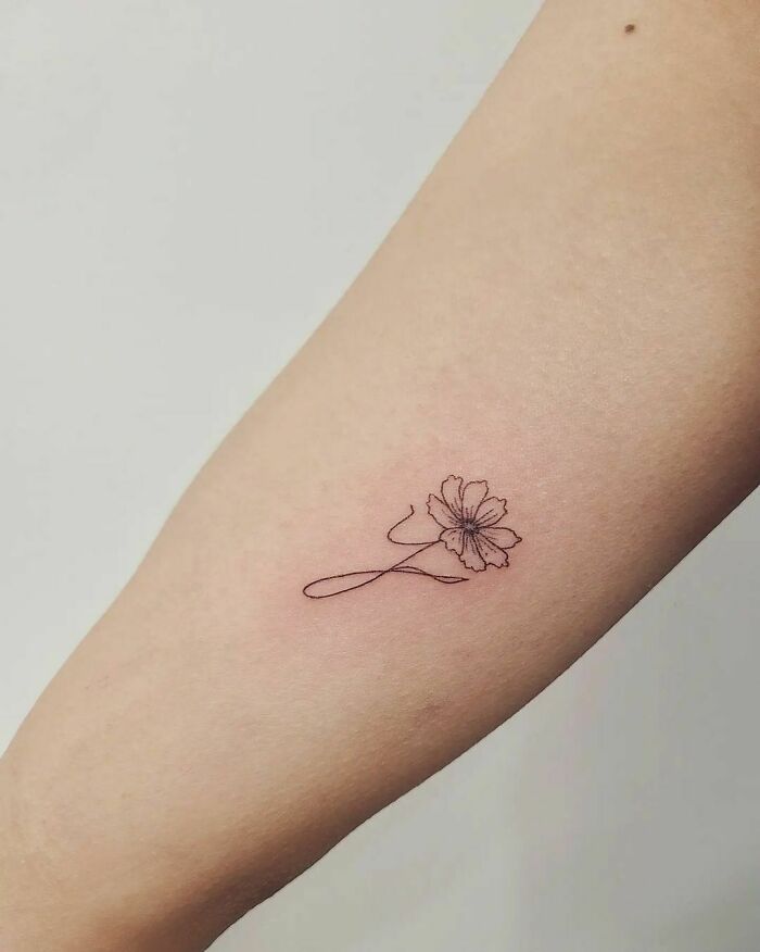 Minimalist flower tattoo on arm celebrating the mother-child bond.