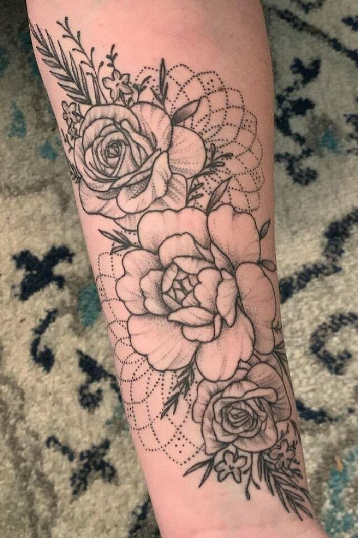 Floral mom tattoo on arm, showcasing intricate roses and dots, symbolizing mother-child bond.