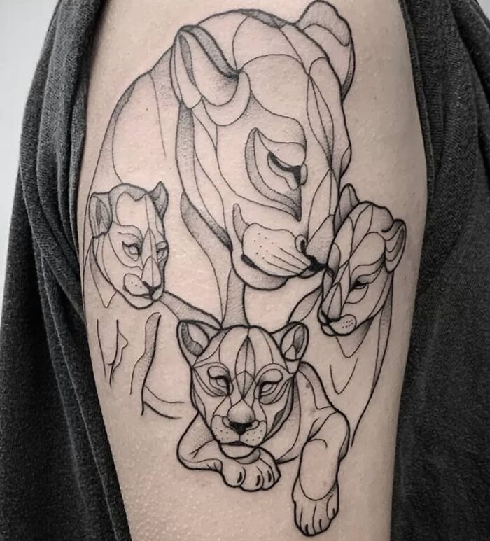 Lion family tattoo celebrating the mother-child bond, showcasing intricate line art on skin.