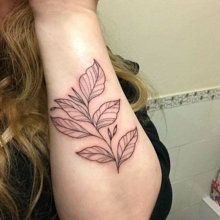 Leaf tattoo design on forearm symbolizing the beautiful mother-child bond.