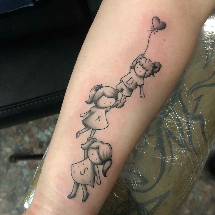 Mom tattoo featuring three children holding a heart-shaped balloon, symbolizing the mother-child bond.