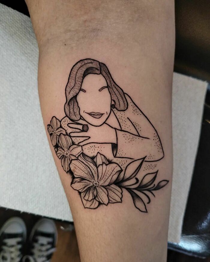 Tattoo of a mother with flowers, symbolizing the mother-child bond.