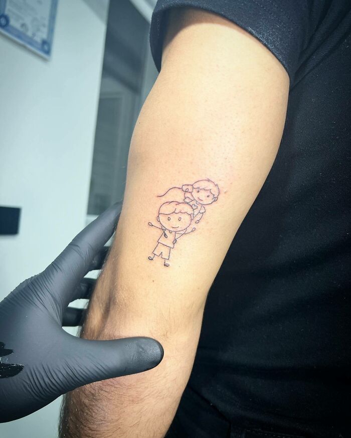 Simple mom tattoo on forearm, featuring a child drawing style, celebrating the mother-child bond.