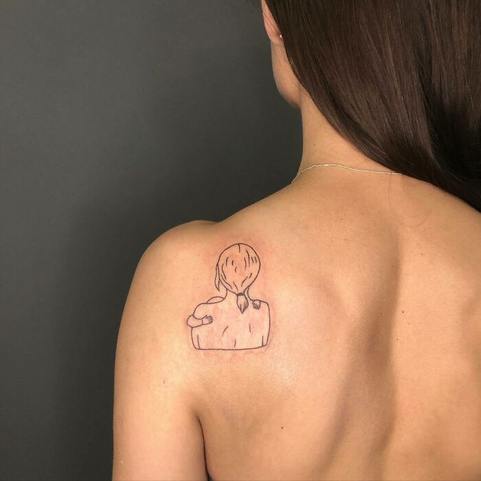 Minimalist mom tattoo on shoulder, featuring a mother and child embracing, symbolizing the mother-child bond.