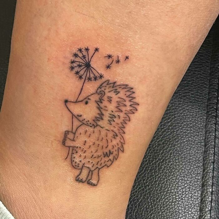 Cute hedgehog holding a dandelion tattoo celebrating the mother-child bond.