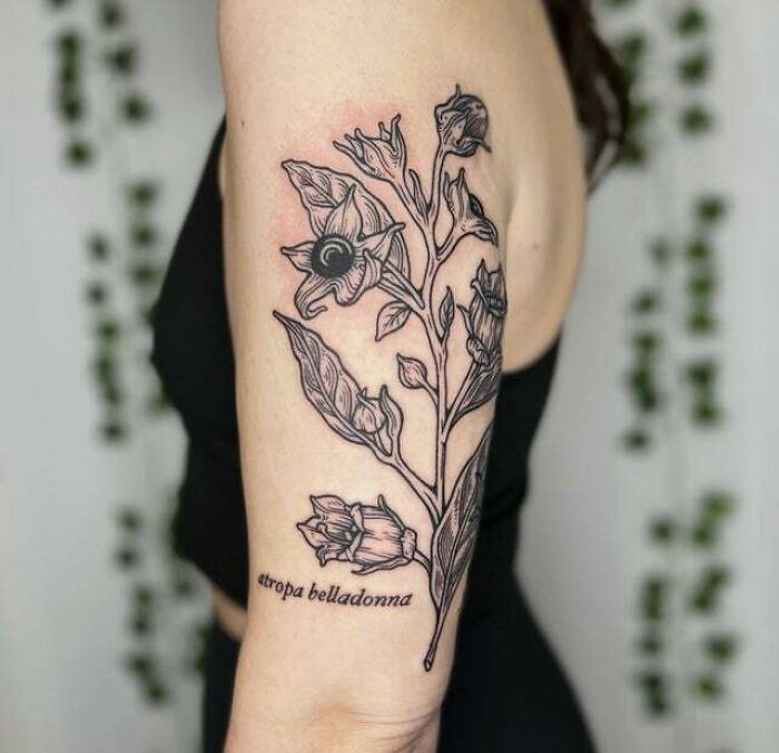 Floral mom tattoo design on a woman's arm, featuring detailed leaves and flowers to symbolize the mother-child bond.
