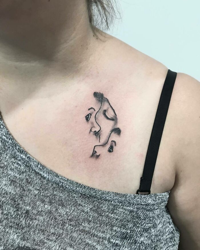 Minimalist mom tattoo depicting a mother and child, celebrating their bond, on a person's chest near the collarbone.