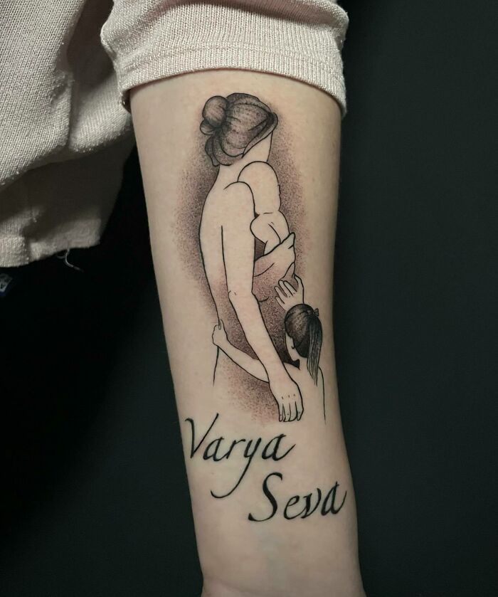 Tattoo of a mother with two children, symbolizing the mother-child bond, with the names Varya and Seva underneath.