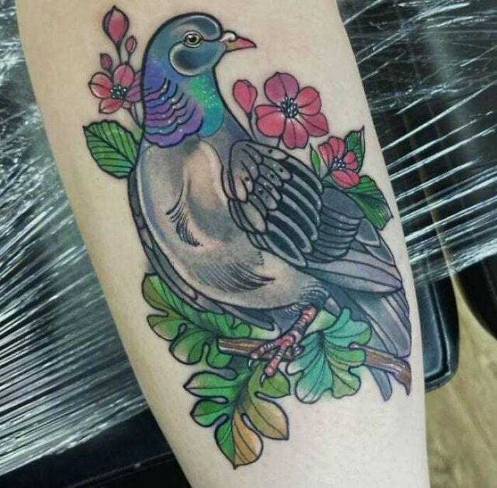 Pigeon tattoo with flowers on arm, representing beautiful mom tattoo idea celebrating the mother-child bond.