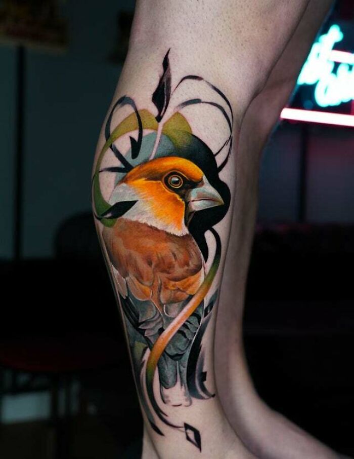 Colorful bird tattoo with abstract accents on leg, showcasing mom tattoo ideas and artistic design.