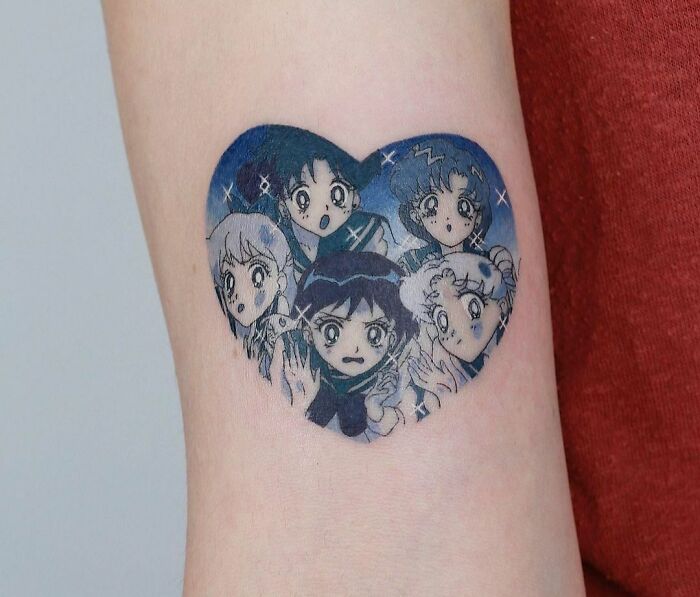 Cartoon tattoo featuring five anime-style Sailor Moon characters in a heart shape, with a nostalgic design.