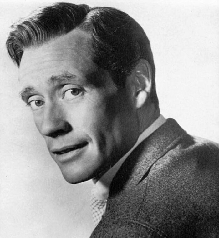 Mel Ferrer in a suit, representing famous people who got married multiple times, in a classic black and white portrait.