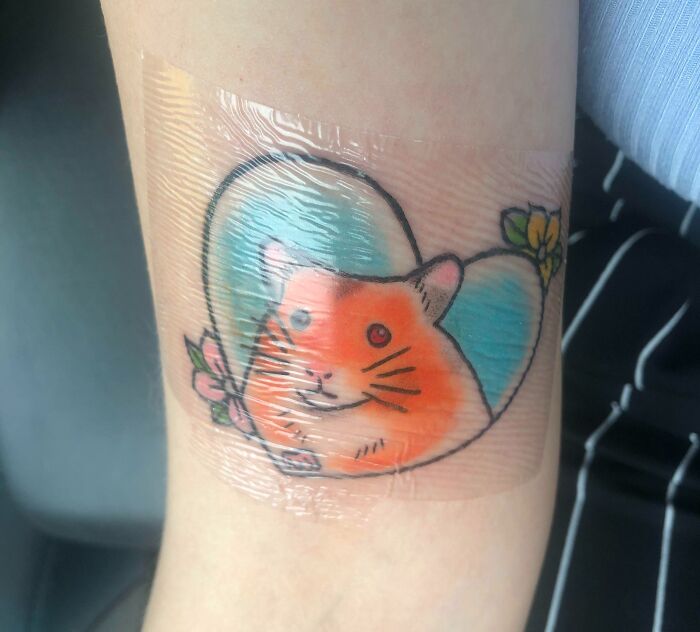 Vibrant pet tattoo of a hamster in a heart shape, symbolizing the bond between humans and pets.