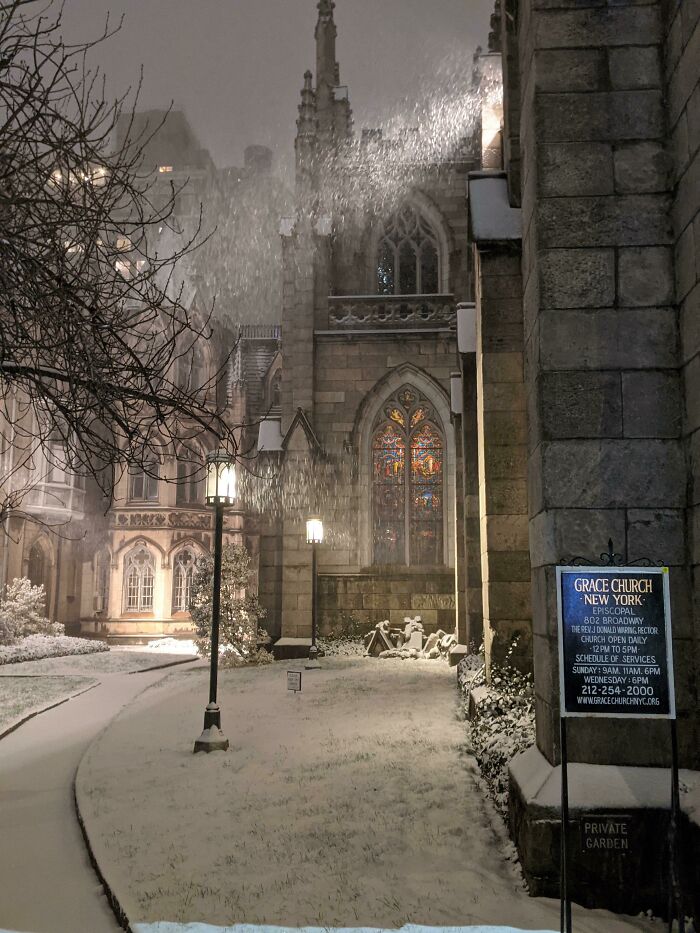 Snow falling over Grace Church in New York, highlighting unique and funny scenes that show New York unlike any other city.