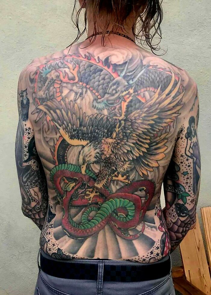 Detailed back tattoo depicting an eagle and serpent, showing how ink changes over the years.