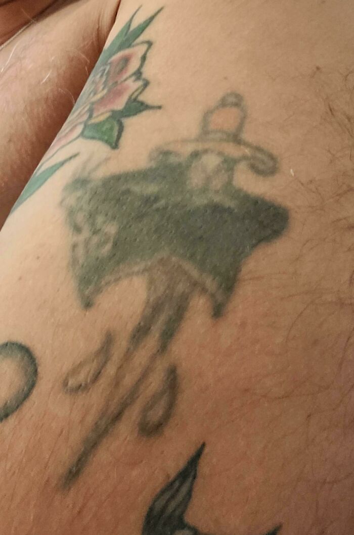 Aged tattoo with faded ink of a sombrero and flower, illustrating how tattoos change over the years.