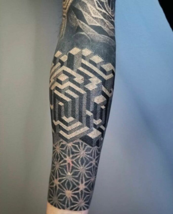 Intricate optical illusion tattoo design on a forearm, featuring geometric patterns and 3D effects.