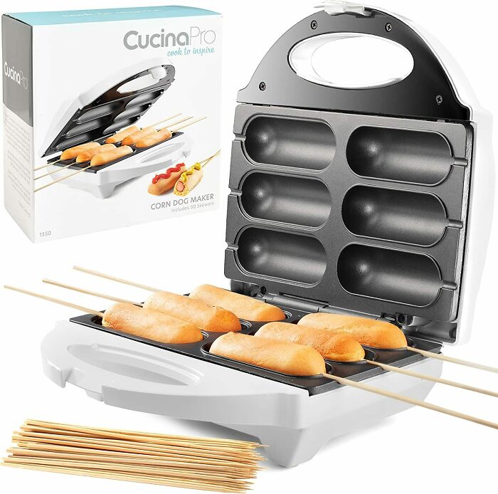 White and black corn dog maker with corndogs inside near a box 