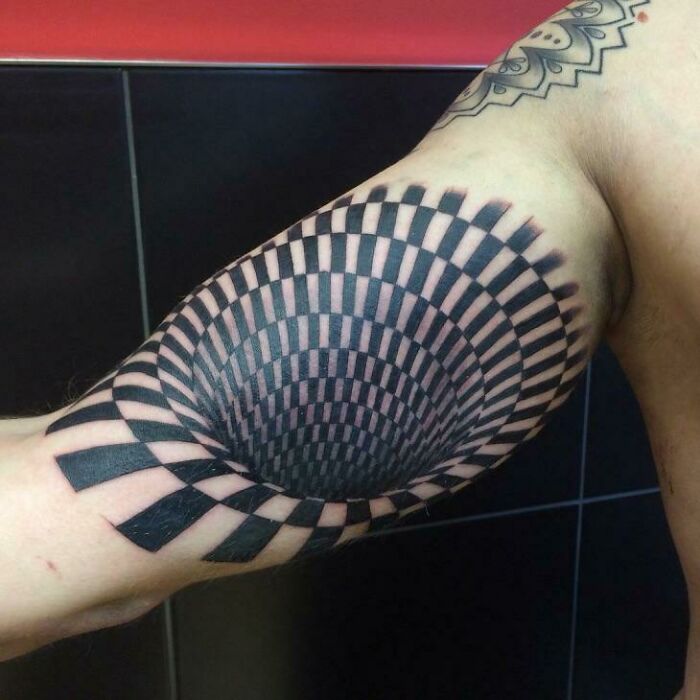Optical illusion tattoo on an arm, resembling a 3D spiral design playing tricks on eyesight.