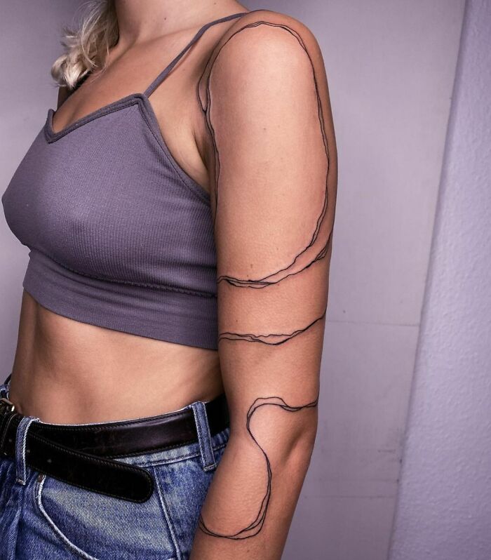 Minimalism line tattoo on a woman's arm, showcasing unique design and style for tattoo enthusiasts.