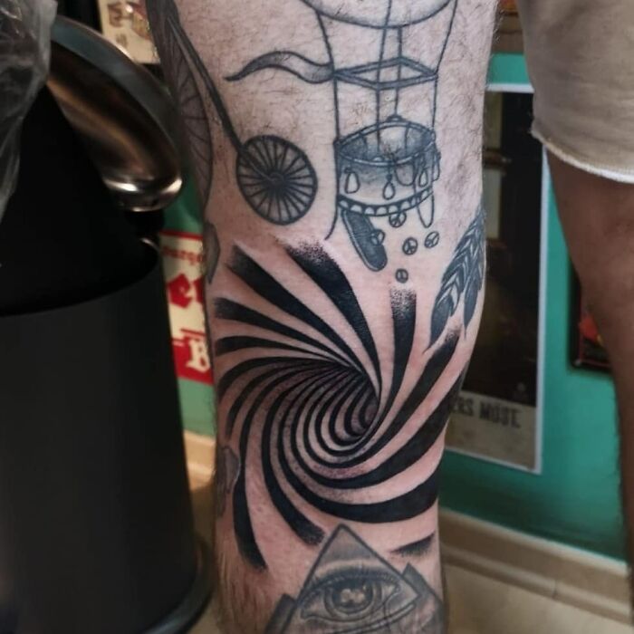 Optical illusion tattoo featuring a spiral design on a person's leg, creating a visually intriguing effect.