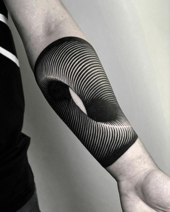 Optical illusion tattoo with swirling lines creating a 3D effect on forearm.