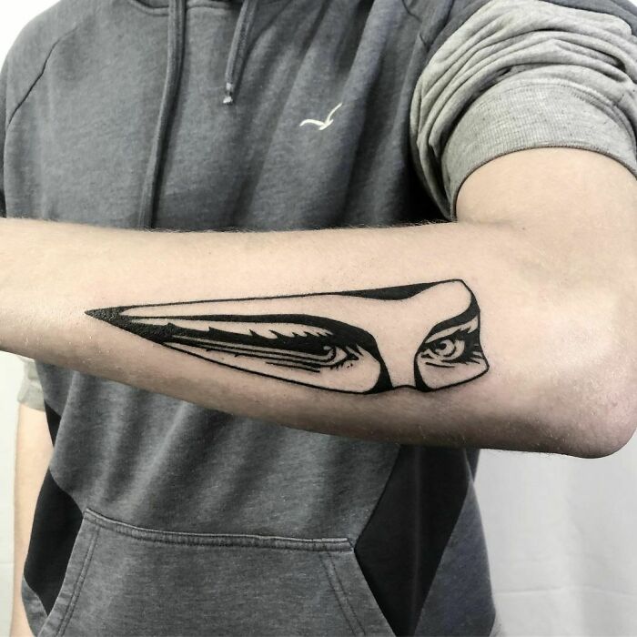 Forearm with optical illusion tattoo featuring eye and mind-bending design, creating a dramatic visual effect.