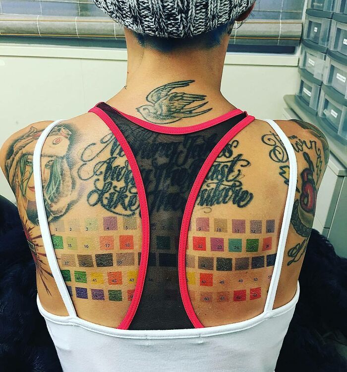 Celebrity tattoos on person's back, featuring color swatches and text, showcasing artistic body art.