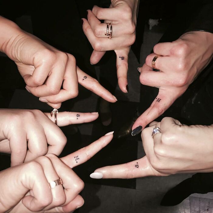 Celebrity tattoos on fingers, featuring small letters, shown as inspiration for a tattoo appointment.